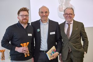 DEPV-Geschäftsführer Martin Bentele (re.) verabschiedet die langjährigen Vorstandsmitglieder Pascal Schiep (li.) und Markus Böll mit dem „Berliner Pelletbären“ und guter Lektüre. © DEPV/Viviane Wild