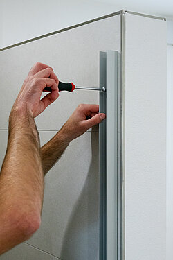 Mit einem Schraubendreher wird das Wandanschlussprofil anschließend fest fixiert. Dann kann die restliche Montage der Dusche erfolgen. Bild: Kermi Duschdesign GmbH