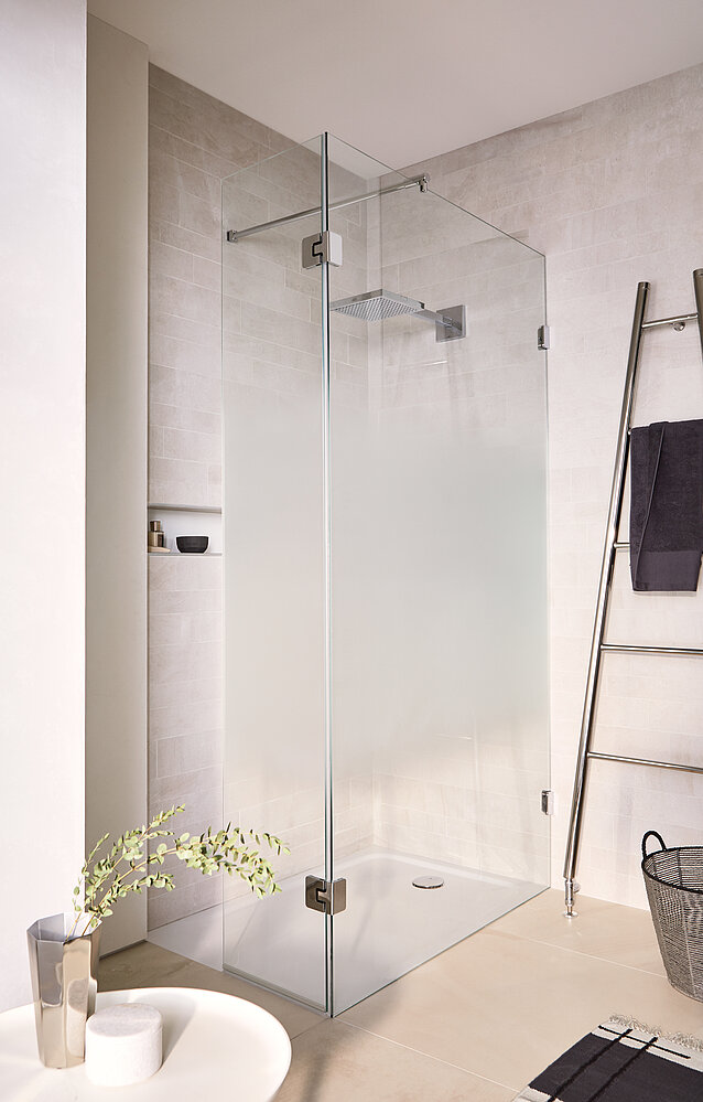 Eine bodenebene, groß bemessene Dusche, die einfachen Zutritt und viel Bewegungsfreiheit gewährt: eine Variante des glassdouche Modells 231 mit einem festen Seiten- und einem Türglas, montiert mit Design-Beschlägen der Serie AUGUSTINA. Bildquelle: Glassdouche
