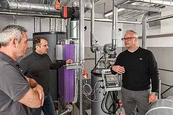 Christian Schober, verantwortlich für die HKL-Haustechnik im BKH, Betriebsleiter Matthias Maschke und Watercryst-Key Account-Manager Torsten Schmidt (v.li.) im Gespräch über den Nachhaltigkeitseffekt, den der chemiefreie Kalkschutz im Bezirkskrankenhaus hat.