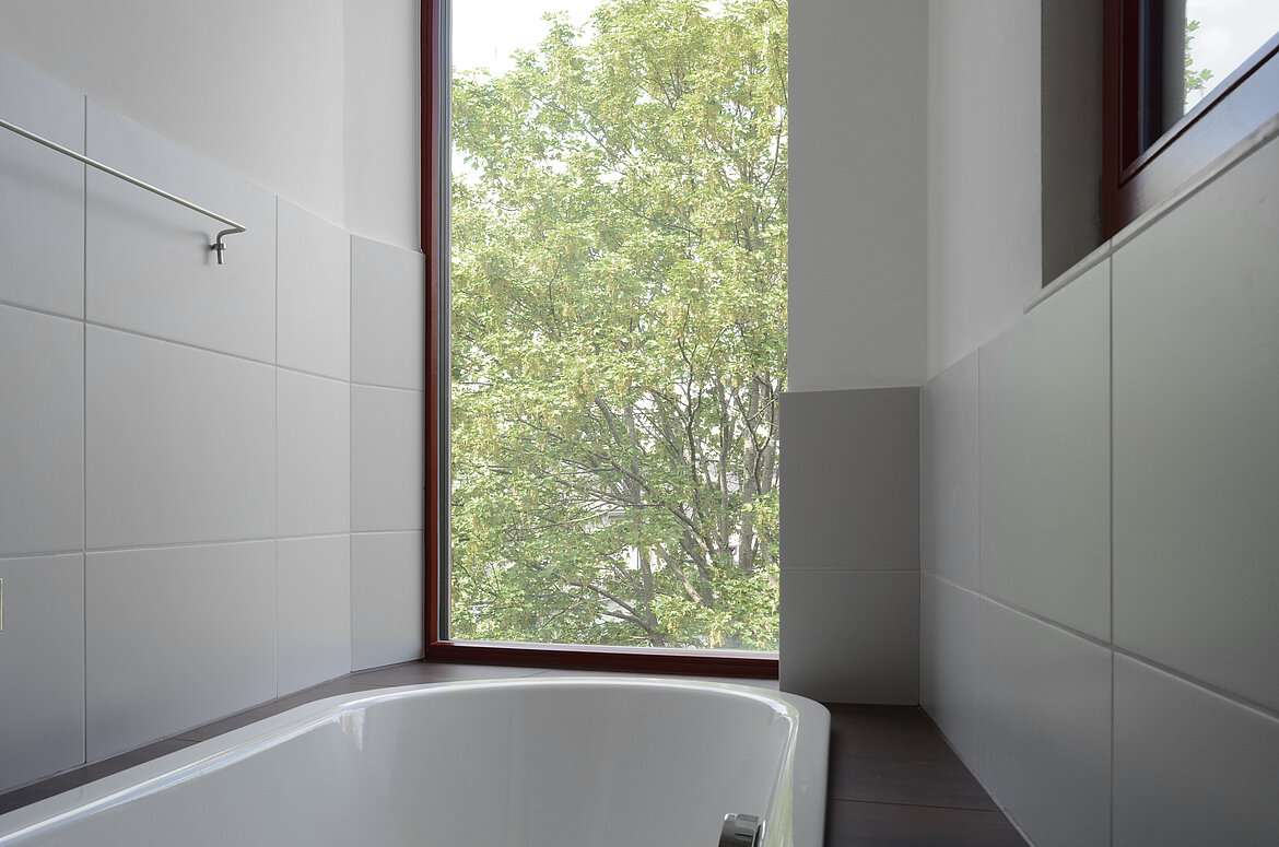 Raumhohe Fenster eröffnen beim Baden den Blick ins Grüne – für ein Spa-Gefühl mitten in der Stadt. Foto: bodensteiner fest